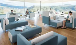 Un espace convivialité entreprise moderne avec des sièges modulables bleus et blancs, offrant une vue panoramique sur des collines verdoyantes.