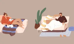 Un homme et une femme profitent d'un moment de pause repos, chacun avec un chat sur le canapé.
