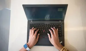 Mains sur un clavier d'ordinateur portable Lenovo, réfléchissant aux 7 critères de choix d'un pc portable.