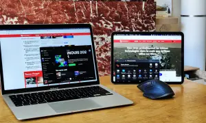Un MacBook Air et une tablette affichent des articles de presse. La tablette ecran pc montre une image de Mars.