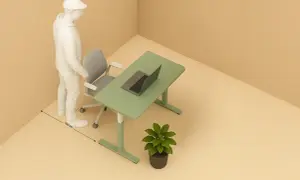 Un homme se tient près d'un bureau vert avec un ordinateur portable. La distance entre le bureau et le mur est de 100 cm.