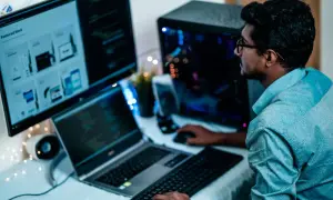 Un homme concentré sur ses écrans, la distance ecran yeux est optimisée pour le travail.