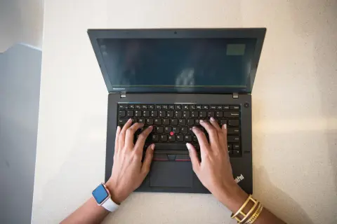 Mains sur un clavier d'ordinateur portable Lenovo, réfléchissant aux 7 critères de choix d'un pc portable.