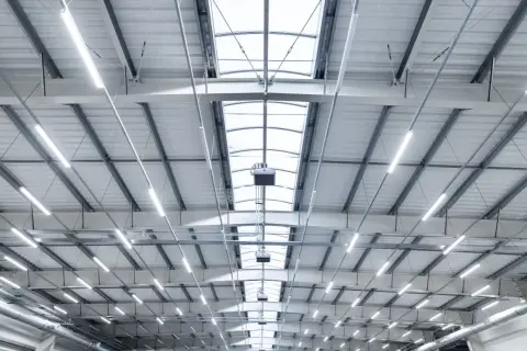 Plafond d'entrepôt moderne avec éclairage LED et lanterneaux, conforme aux normes nf x35-203/iso 7730.