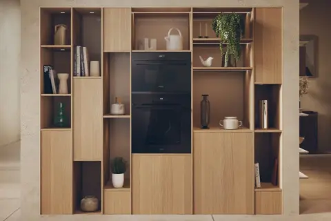 Élégante niche murale en bois clair intégrant un micro-ondes et un four. La largeur micro onde est parfaitement intégrée dans cette composition.