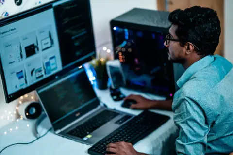 Un homme concentré sur ses écrans, la distance ecran yeux est optimisée pour le travail.