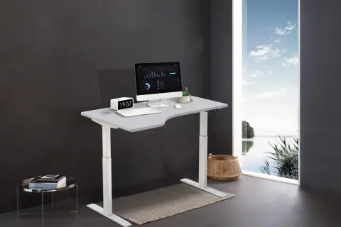 Bureau moderne avec plan de travail ergonomique, ordinateur, horloge et vue sur la nature. Une idée pour un espace de travail inspirant.