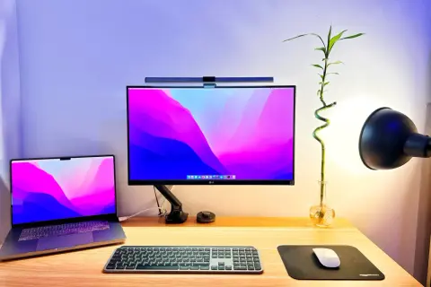 Un bureau de rêve pour un setup développeur : MacBook, écran LG, clavier et souris, avec une touche de verdure.