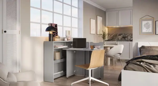 Bureau compact et lit dans une chambre, optimisant l'espace.