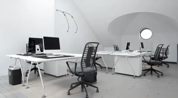 Bureau moderne avec postes de travail épurés, chaises ergonomiques et éclairage soigné, idéal pour le métier d'ergonome.