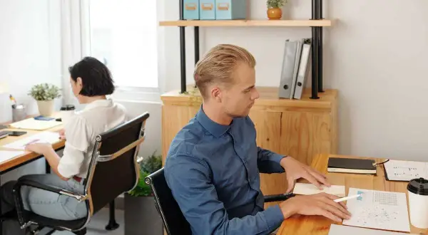 Un homme et une femme travaillent dans des bureaux séparés. Mon employeur me demande de changer de bureau, mais je préfère rester ici.