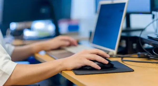 Main gauche sur la souris, main droite sur le clavier. Le travail sur ordinateur peut causer une douleur épaule.