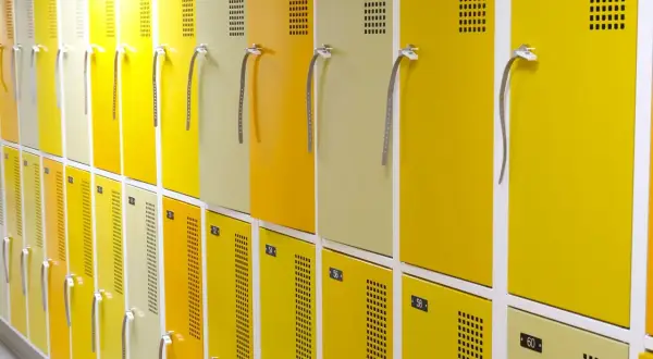 Rangée de casiers jaunes et beiges, numérotés, conformes au vestiaire code du travail.