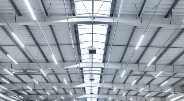 Plafond d'entrepôt moderne avec éclairage LED et lanterneaux, conforme aux normes nf x35-203/iso 7730.