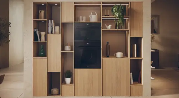 Élégante niche murale en bois clair intégrant un micro-ondes et un four. La largeur micro onde est parfaitement intégrée dans cette composition.