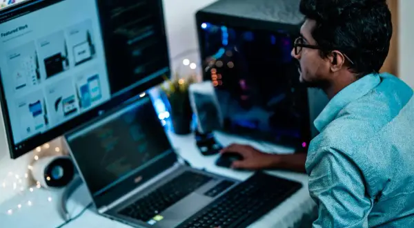 Un homme concentré sur ses écrans, la distance ecran yeux est optimisée pour le travail.