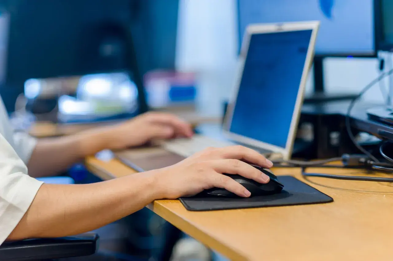 Main gauche sur la souris, main droite sur le clavier. Le travail sur ordinateur peut causer une douleur épaule.