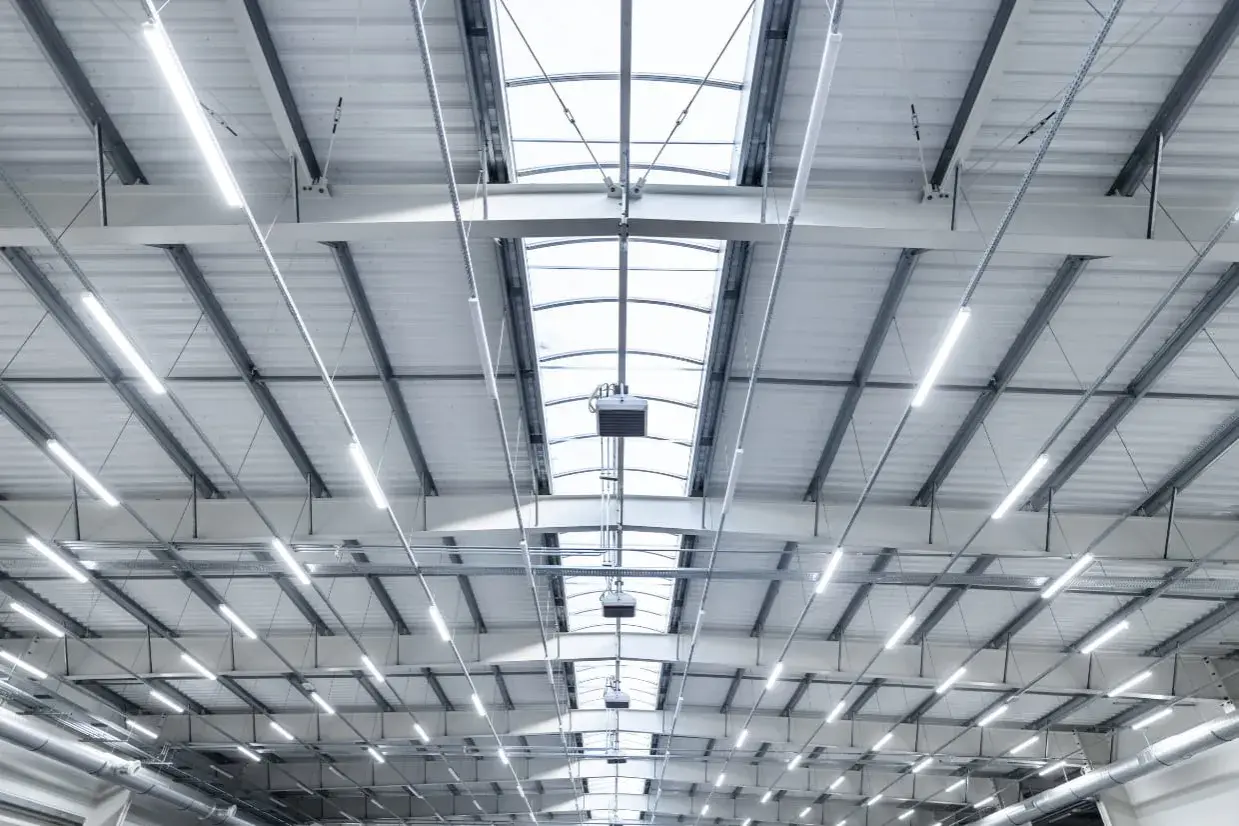Plafond d'entrepôt moderne avec éclairage LED et lanterneaux, conforme aux normes nf x35-203/iso 7730.