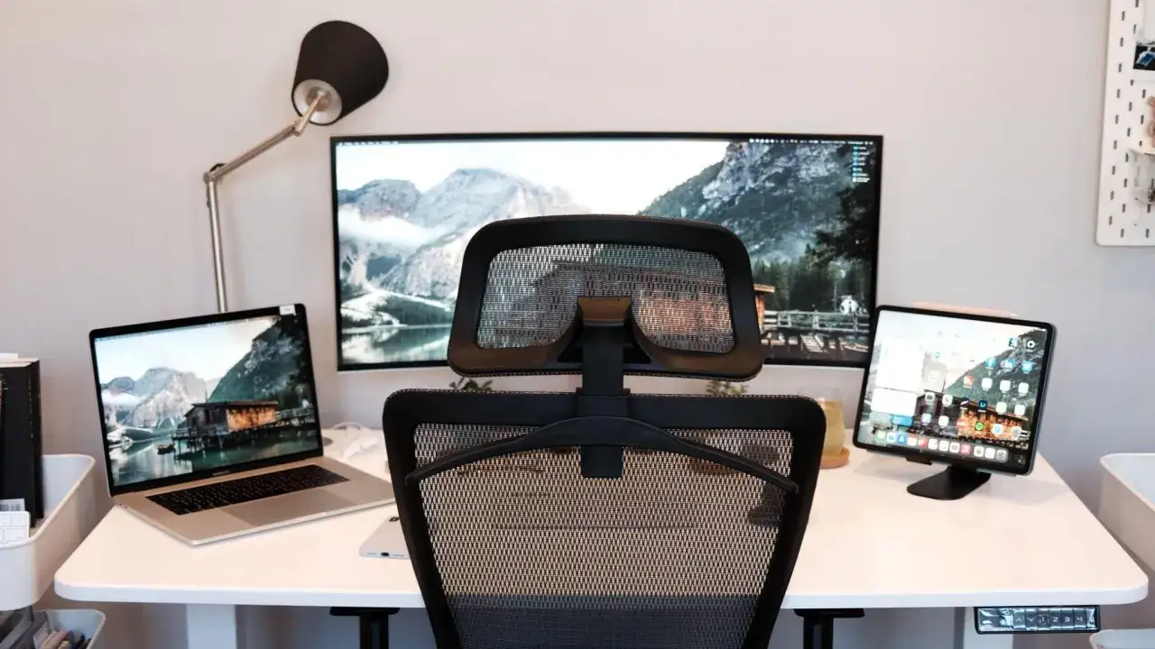 Un bureau moderne avec un ordinateur portable, un grand &eacute;cran et une tablette, parfait pour un setup d&eacute;veloppeur.