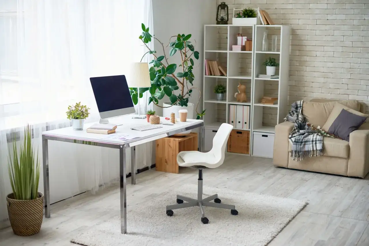 Bureau lumineux avec ordinateur, plantes et fauteuil confortable. Id&eacute;al pour le t&eacute;l&eacute;travail raison m&eacute;dicale.