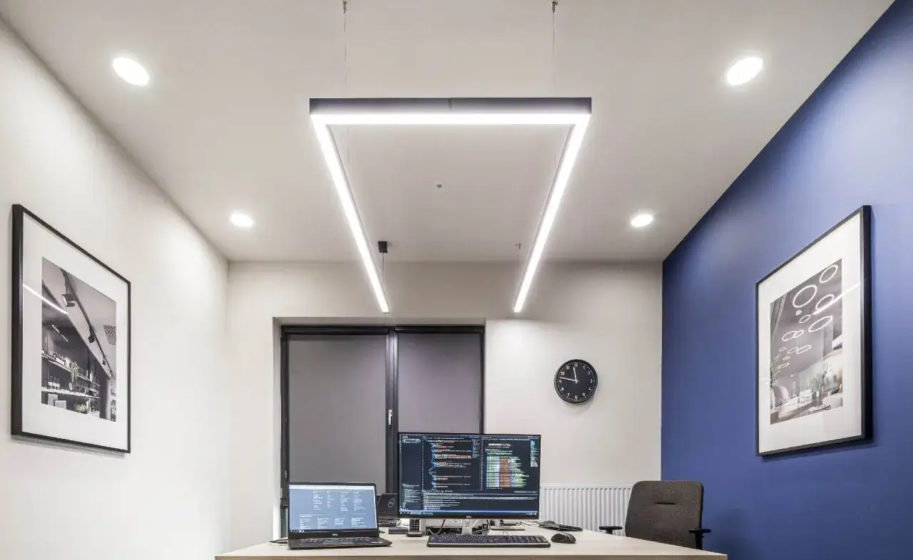 Bureau moderne avec postes informatiques, &eacute;clairage conforme &agrave; l'article R4223-13 du code du travail, et d&eacute;corations murales.