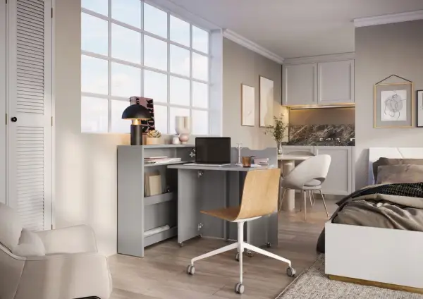 Bureau compact et lit dans une chambre, optimisant l'espace.