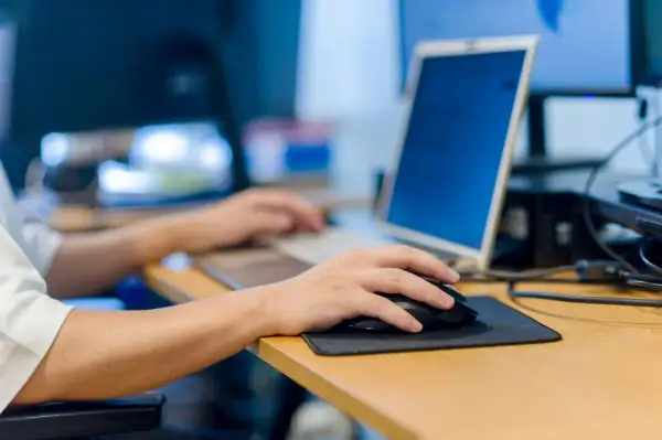 Main gauche sur la souris, main droite sur le clavier. Le travail sur ordinateur peut causer une douleur épaule.