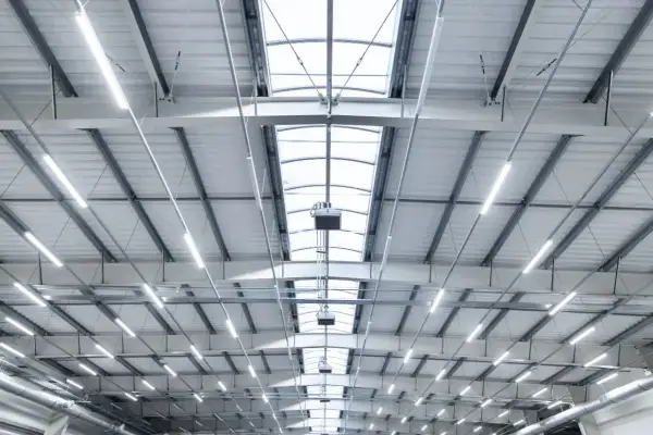 Plafond d'entrepôt moderne avec éclairage LED et lanterneaux, conforme aux normes nf x35-203/iso 7730.