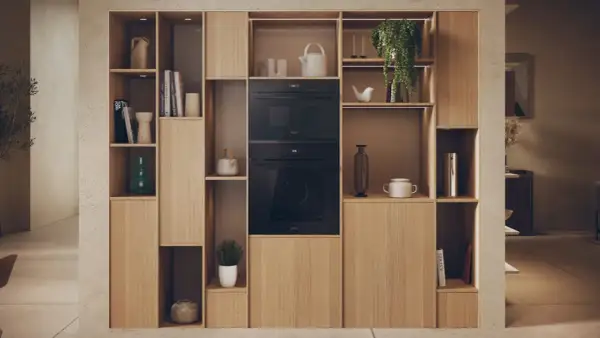 Élégante niche murale en bois clair intégrant un micro-ondes et un four. La largeur micro onde est parfaitement intégrée dans cette composition.