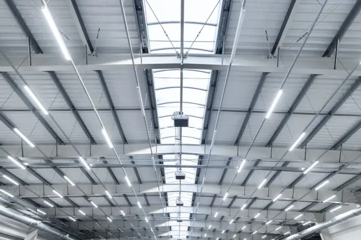 Plafond d'entrepôt moderne avec éclairage LED et lanterneaux, conforme aux normes nf x35-203/iso 7730.